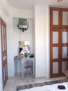 a bedroom with a desk and a tv on a wall at Valenthia in Agios Ioannis Pelio