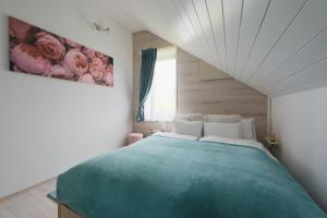 a bedroom with a large bed with a painting on the wall at Lotti Residnece Familyar in Balatonfüred