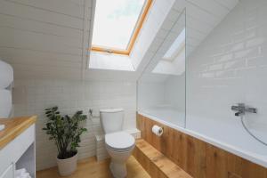 a bathroom with a white toilet and a skylight at Lotti Residnece Familyar in Balatonfüred