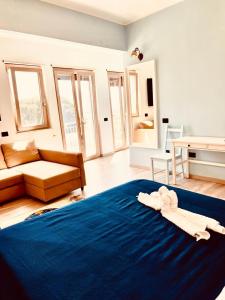 uma sala de estar com uma cama azul e um sofá em La Casa di Eolo em Licata
