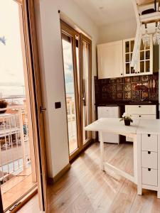 uma cozinha com uma mesa branca e uma grande janela em La Casa di Eolo em Licata
