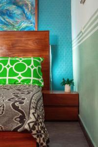 a bedroom with a bed with a green pillow at PALM Springs Bed & Breakfast in Limbe