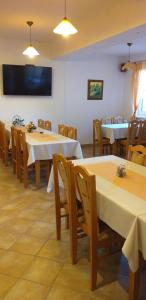 jadalnia ze stołami i krzesłami oraz telewizorem w obiekcie Penzión Lúčky w mieście Lúčky