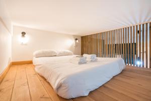 sypialnia z dużym białym łóżkiem z ręcznikami w obiekcie Aguirre apartment by People Rentals w mieście Bilbao