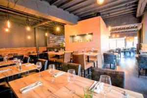 een restaurant met houten tafels en stoelen met wijnglazen bij Hotel L'Esprit Sain in Malmedy