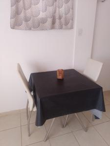 stół z dwoma krzesłami i czarną tkaniną w obiekcie Dante's apartment w mieście San Luis