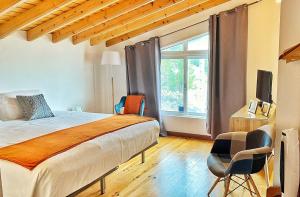 een slaapkamer met een bed en stoelen en een raam bij Miradouro da Papalva Guest House - Pico - Azores in São João