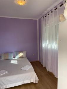 a bedroom with a white bed and a window at Rooms Florie in Becici