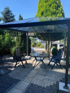 a table and chairs under a blue umbrella at FeWo Walburga in Roßbach