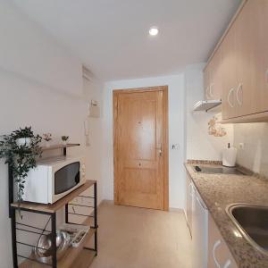 a small kitchen with a microwave on a counter at Apartamentos Vicenta Playa Carihuela in Torremolinos