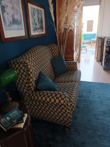 uma sala de estar com um sofá xadrez com duas almofadas em Ada Rooms em Locogrande