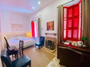 a bedroom with red windows and a bed and a desk at The Maltese Sun in Sliema