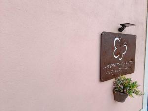 een bord op een roze muur met een plant bij La Casa di Amelia in Ruviano