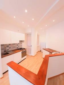 a kitchen with white cabinets and a wooden floor at Trilo Conero, in residence con piscina ed aria condizionata vicino al mare in Marcelli