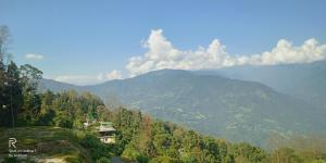 a view of a mountain with a house on a hill at Atithi Griha Homestay - ARITAR, SILK ROUTE, SIKKIM in Aritar
