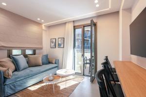 ein Wohnzimmer mit einem blauen Sofa und einem Tisch in der Unterkunft Old City Apartments in Iraklio