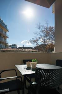 un tavolo e sedie su un balcone con tavolo e finestra di Old City Apartments a Heraklion