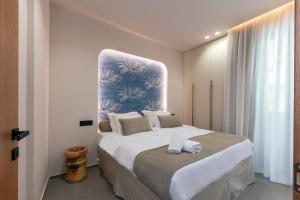 een slaapkamer met een groot bed en 2 handdoeken bij Old City Apartments in Heraklion