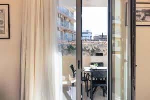 een kamer met een balkon met een tafel en stoelen bij Old City Apartments in Heraklion