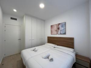 um quarto com uma grande cama branca e 2 toalhas em Apartamento Horta de Santa Maria em Cambrils