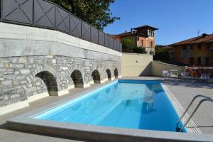 a large swimming pool next to a stone wall at Casa Castellino by LoveComo in Menaggio