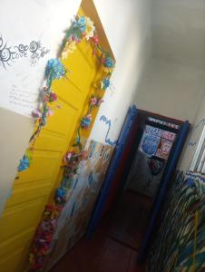una habitación con una puerta amarilla con flores en la pared en Ruuhma en Salta