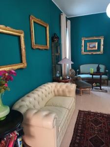 salon z białą kanapą i niebieskimi ścianami w obiekcie Ada Rooms w mieście Locogrande