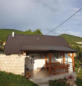 a small house with a deck and a roof at KUĆA ZA ODMOR RAVANČIĆ in Prozor