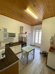 een keuken met een tafel en een koelkast en een tafel bij appartement climatisé,IDEALEMENT SITUE 100m du vieux port. in Bastia