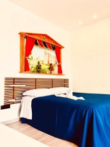um quarto com uma cama azul e um espelho em La Casa di Eolo em Licata