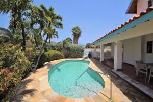 a swimming pool in the backyard of a house at Agave Gardens in Palm-Eagle Beach