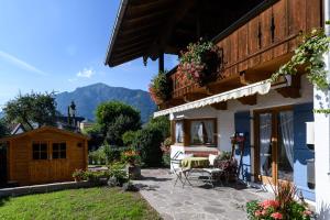 Un patio de una casa con una mesa y sillas. en Lieblingsort, en Unterwossen