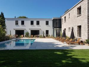 un patio con sillas y una piscina al lado de un edificio en HPC Suites - Parking Gratuit & Piscine Chauffée, en Cassis