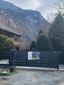 a park bench with a sign in front of a mountain at Le Chalet Carpe Diem in Le Bourg-dʼOisans