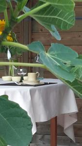 einem weißen Tisch mit zwei Tassen und einer Pflanze in der Unterkunft B&B Bergdal in Gits