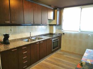a kitchen with wooden cabinets and a sink at Apartamento a 5 minutos distancia de playa en Puerto de Sagunto -Full Apartment -120m2 in Puerto de Sagunto +11 photos