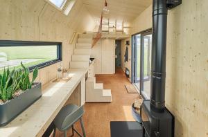 a room with a fireplace in a tiny house at Tiny House Pioneer 2 - Hooksiel im Wangerland in Wangerland