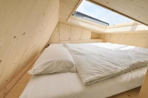 a bed in a small room with a window at Tiny House Pioneer 2 - Hooksiel im Wangerland in Wangerland