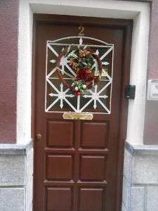 Una puerta marrón con una corona de Navidad. en Habitación en costa vasca a 7 minutos de la playa en Mutriku