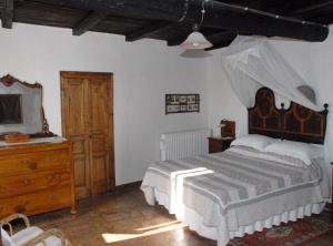 a bedroom with a large bed and a wooden dresser at CASALE SPOLETO in Spoleto
