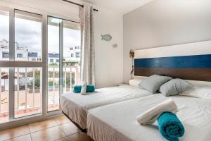 sypialnia z 2 łóżkami i dużym oknem w obiekcie Villa Paraíso w Corralejo