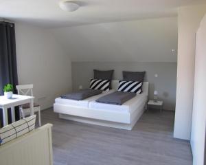 ein Schlafzimmer mit einem großen weißen Bett in einem Zimmer in der Unterkunft FeWo-Möwenpaar-Norden-Norddeich in Norden