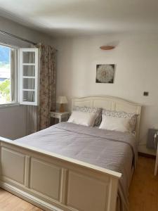 een slaapkamer met een groot wit bed en een raam bij le Strelitzia 1 in Cilaos