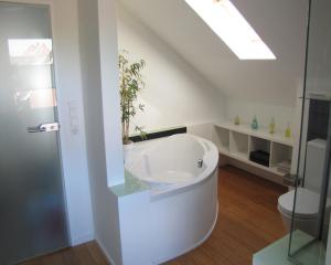 a white bathroom with a tub and a toilet at FeWo-Möwenpaar-Norden-Norddeich in Norden +20 photos