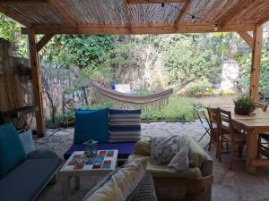 un patio con hamaca, mesa y sillas en Galilean villa with jacuzzi, en Qiryat ‘Amal