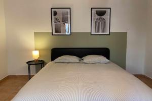 um quarto com uma cama com três fotografias na parede em Love nest with sea view in the heart of the Panier em Marselha