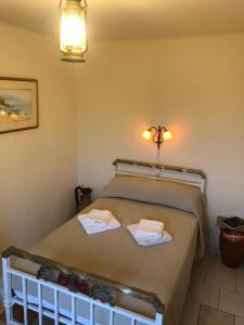 una camera da letto con un letto con due asciugamani sopra di ARETI Sea View Mountain Cottage ad AmigdhalokeFálion