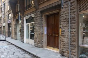 フィレンツェにあるBsj Apartmentの通り側の木製の扉のあるレンガ造りの建物