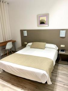 A bed or beds in a room at Pensión Residencia Fornos