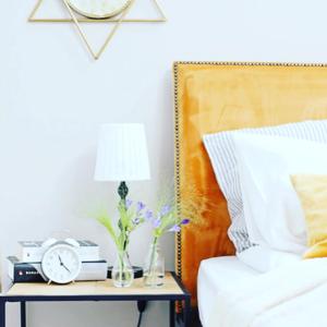 una camera con letto e tavolo con orologio di Moft Loft. Lovely, comfy apartment. a Cluj-Napoca